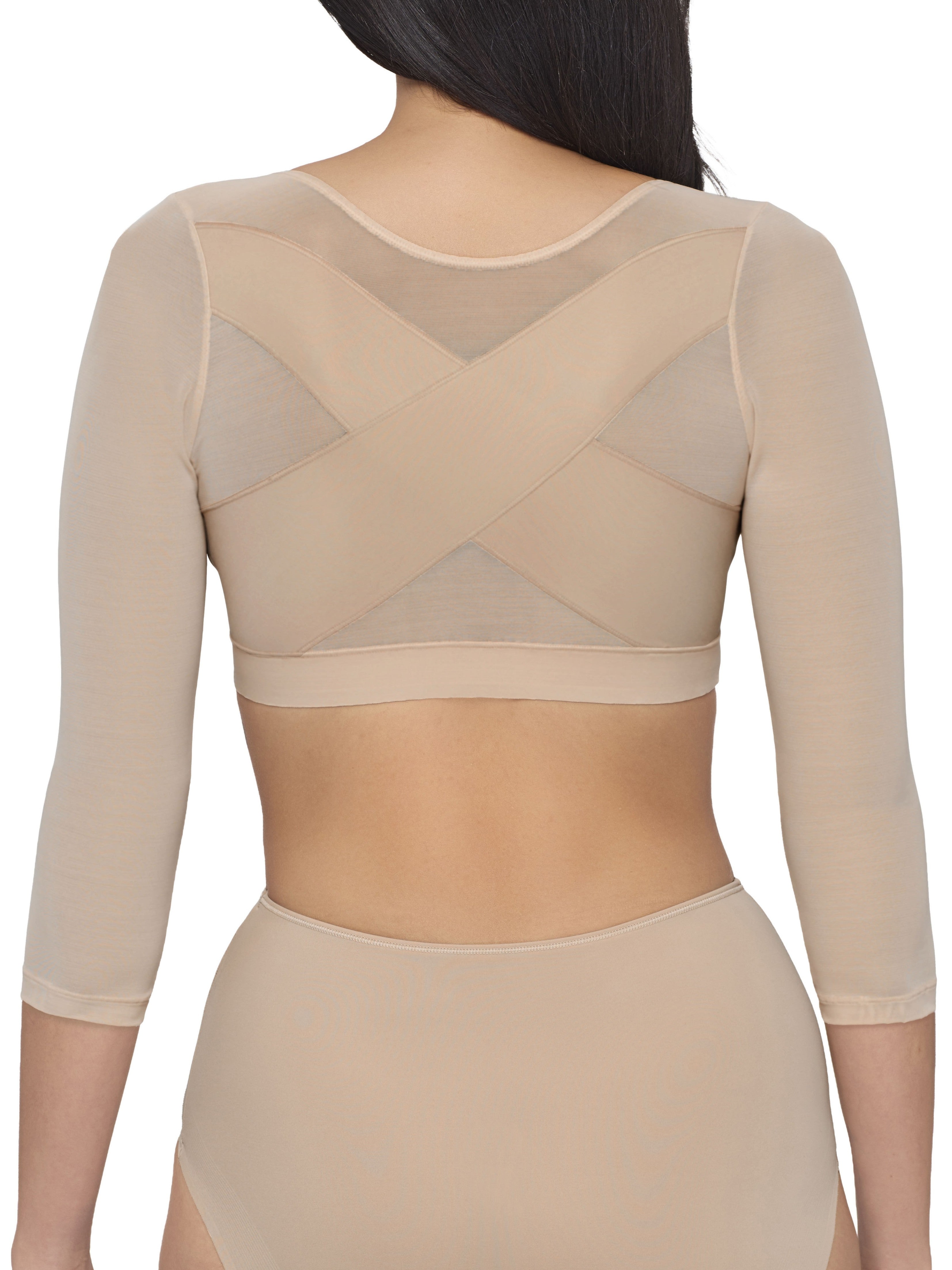 a woman wearing a beige back and arm smoothing cami shapewear