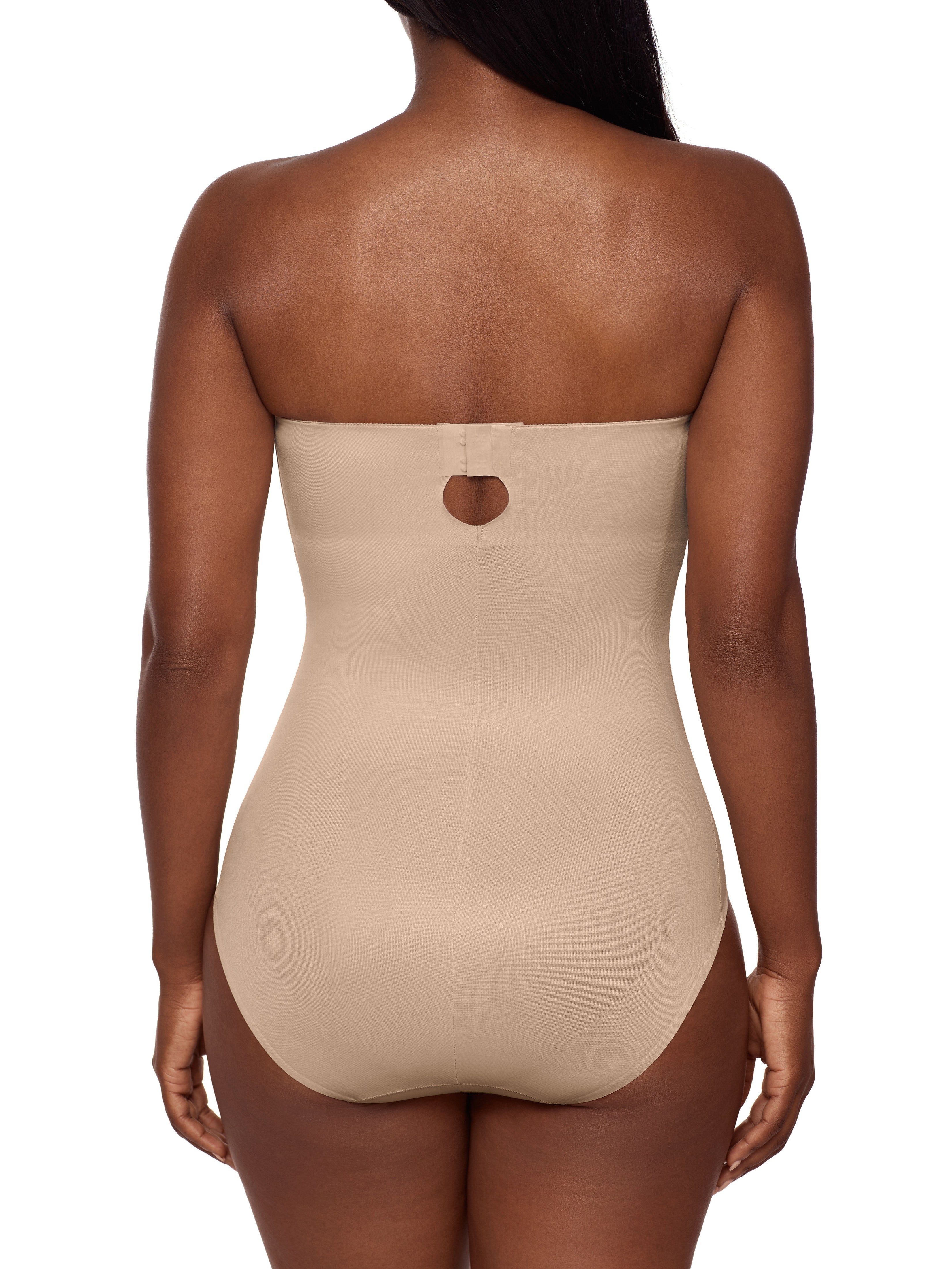 a woman wearing a beige strapless shapewear bodysuit total body shaper