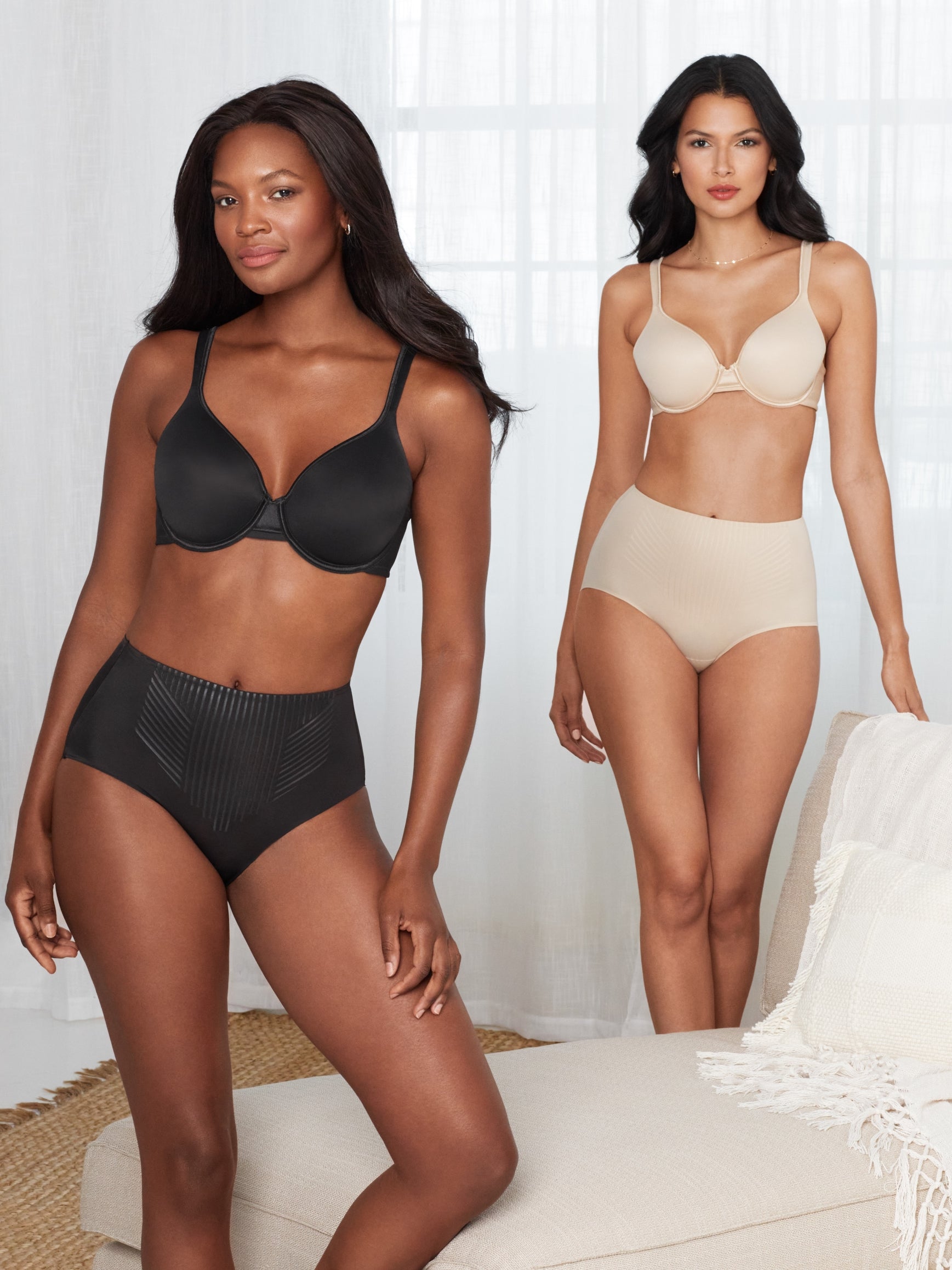 a woman wearing a black shaping brief and a woman wearing a nude shaping brief underwear in a living room all-groups