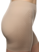 a closeup detail of woman wearing a beige tummy control shapewear short