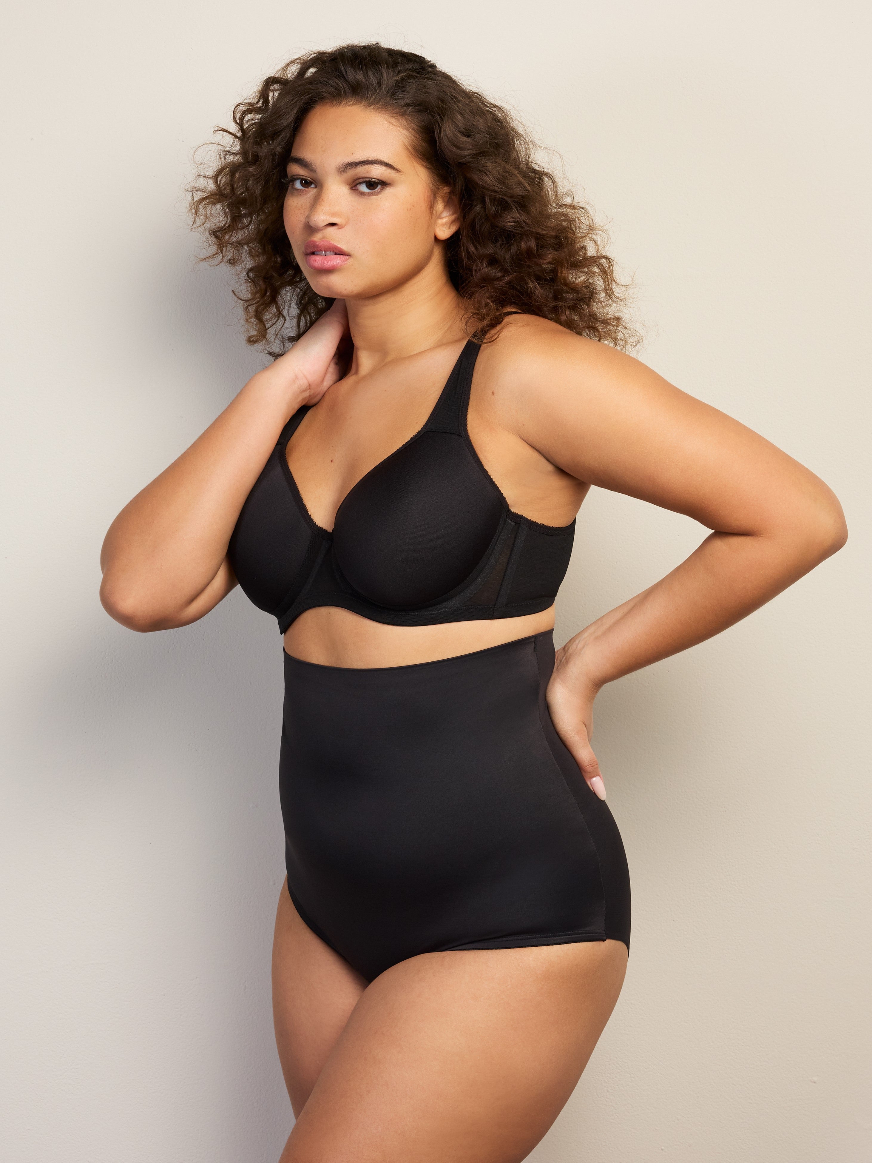 a woman wearing black high waisted tummy control underwear