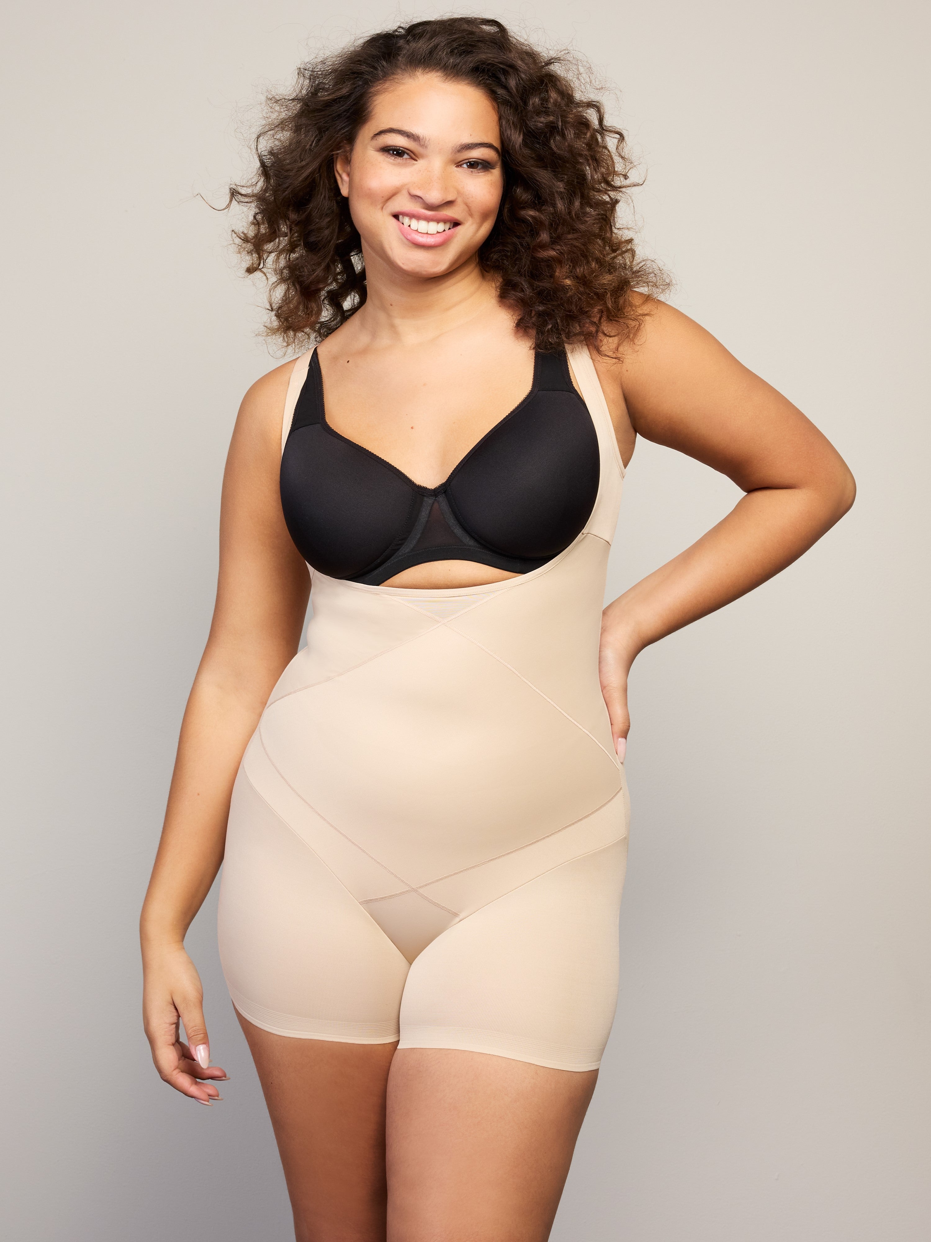 a woman wearing a nude open bust tummy control body shaper shapewear all-groups