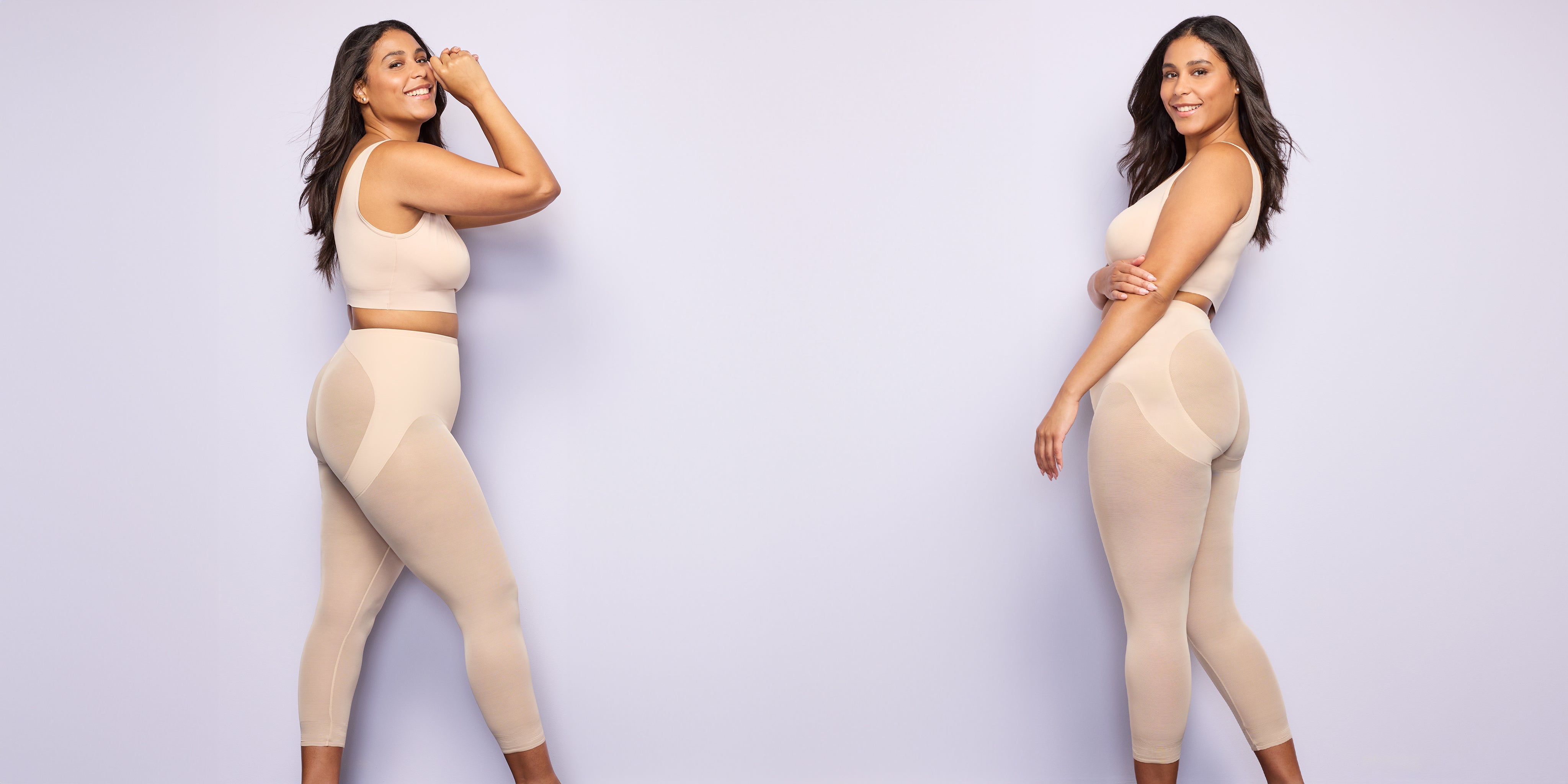 two women wearing nude tummy control leggings and nude bralettes against a lavender colored wall