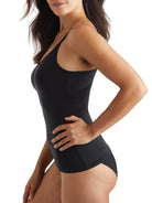 a woman wearing a black tummy control shaping camisole shapewear