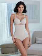 a woman in a living room wearing a nude high waisted tummy control shaping brief shapewear all-groups