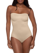 a woman wearing a beige strapless shapewear bodysuit total body shaper