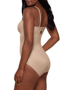 a woman wearing a beige strapless shapewear bodysuit total body shaper