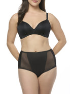 Woman wearing a black bra and shapewear brief set on a white background