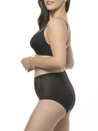 Woman wearing a black bra and shapewear brief set on a white background