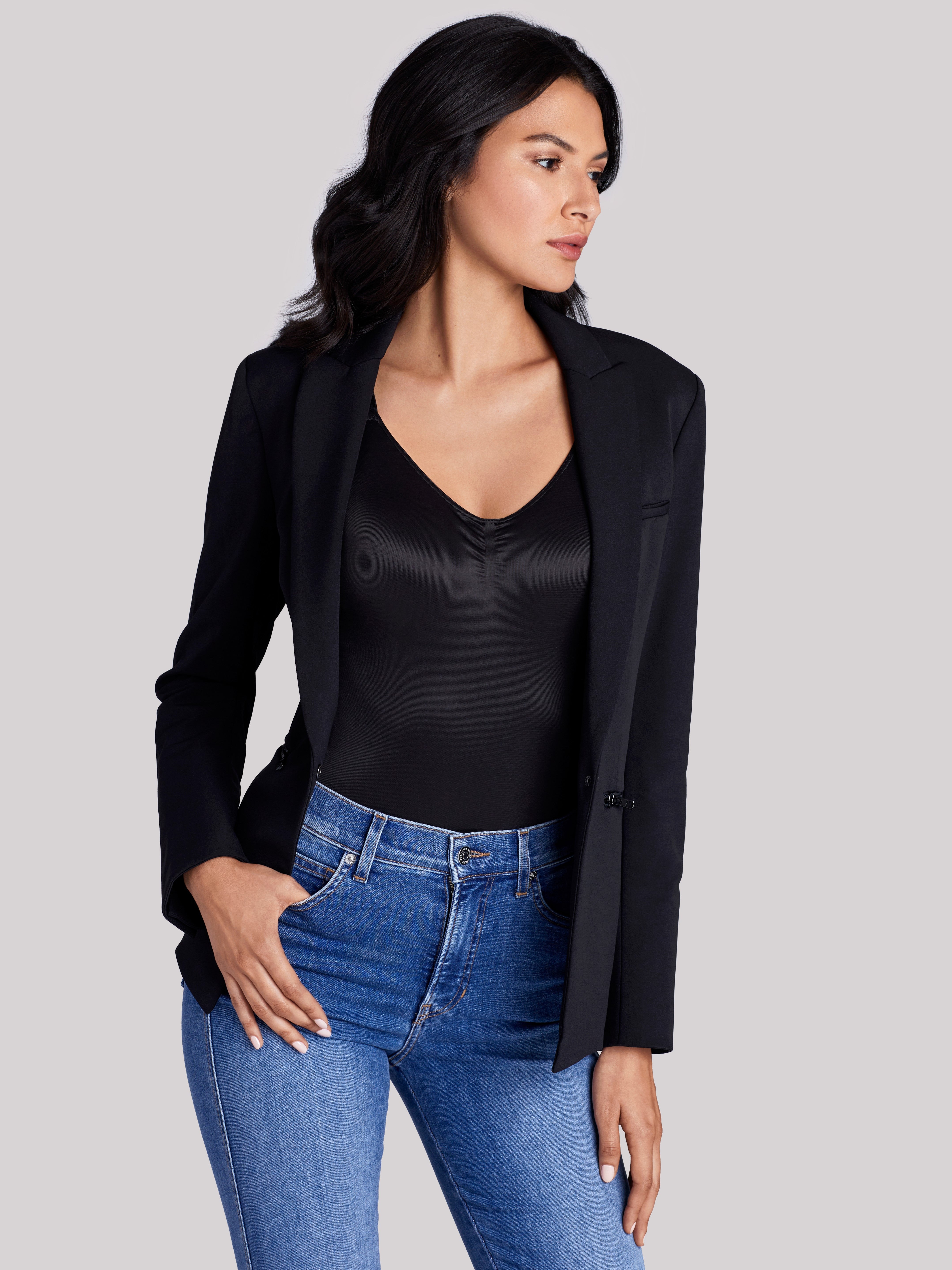 a woman wearing blue jeans, a black bodysuit, and a black jacket all-groups