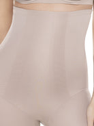 a close-up detail of a woman wearing a beige shaping short