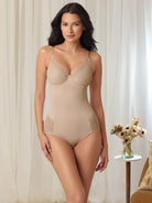 a woman standing in a living room wearing a nude body shaper sheer shapewear all-groups