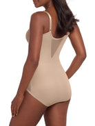 a woman wearing a beige tummy control shaping bodysuit miraclesuit shapewear body shaper sheer shapewear