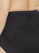 a close-up detail of a woman wearing black tummy control underwear shapewear