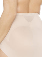 a close-up detail of a woman wearing a beige shaping brief