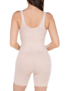 a woman wearing a beige open-bust shaping bodysuit romper