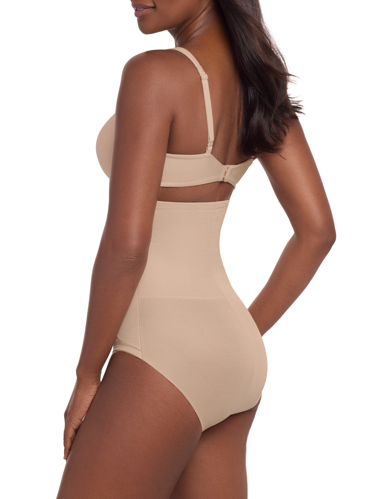 a woman wearing a beige high waisted tummy control brief control top panty miraclesuit shapewear