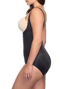 a woman wearing a black open bust body shaper