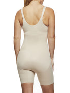 a woman wearing a beige open-bust shaping bodysuit romper