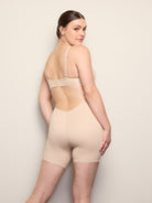 a woman wearing a nude low back shapewear shorts all-groups