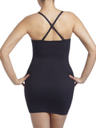 a woman wearing a black tummy control shaping slip body shaper with criss cross straps