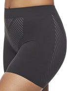 a close-up detail of a woman wearing a black tummy control shapewear short