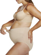 a woman wearing a beige maternity support brief