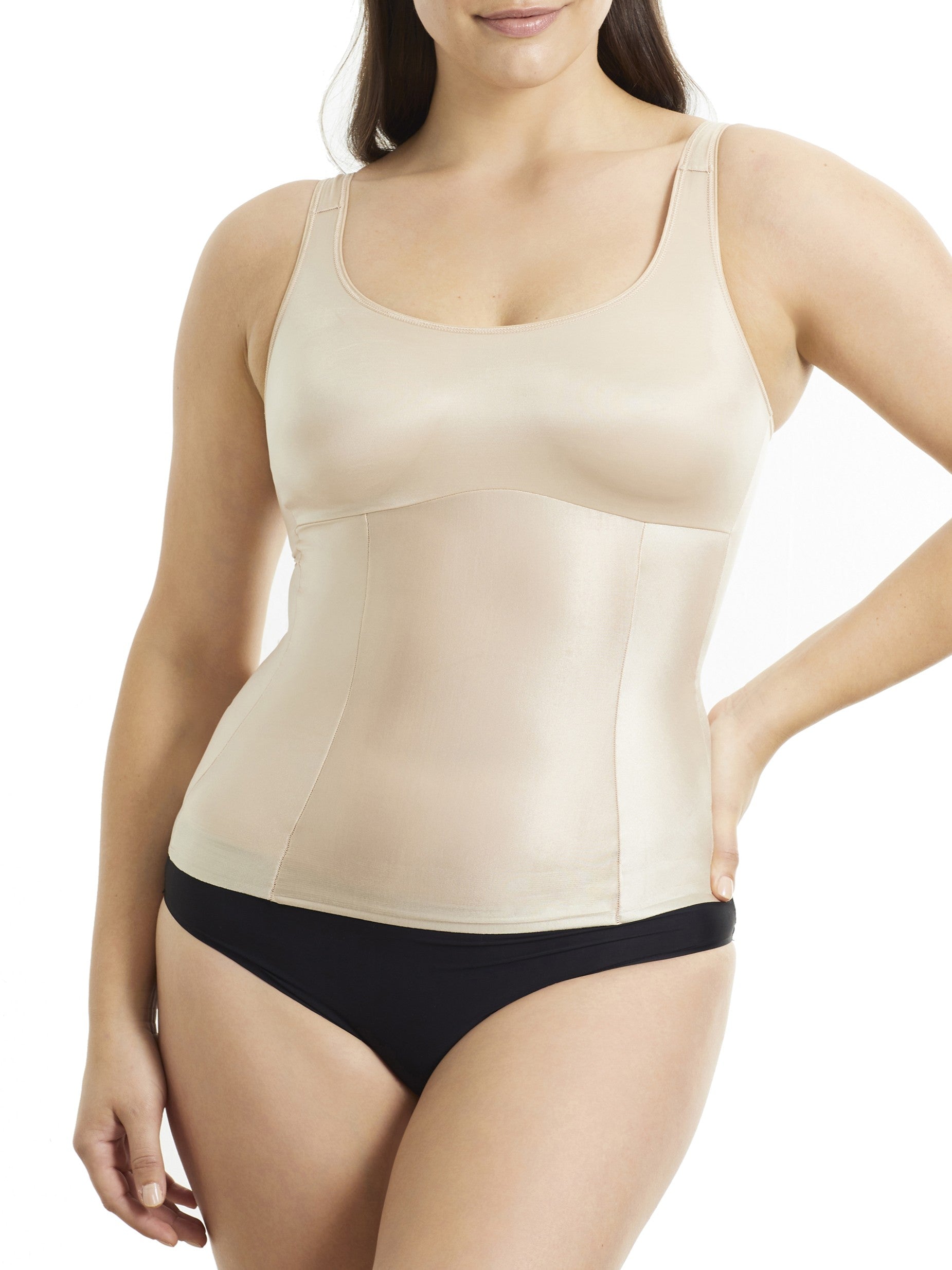 Woman wearing a beige shapewear tank top and black underwear on a white background