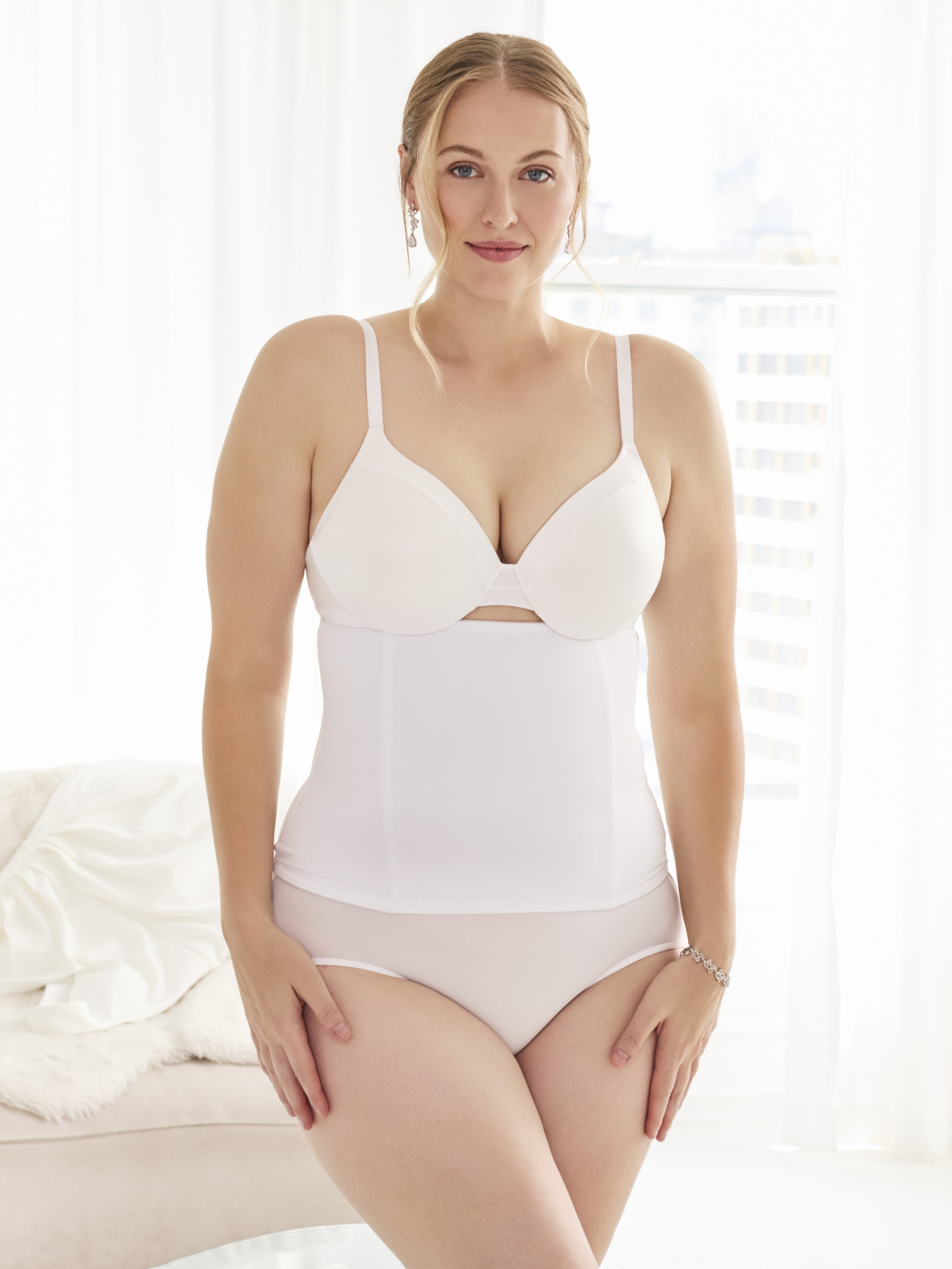 a woman wearing a white waist cincher waist trainer girdle all-groups
