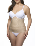 Woman wearing a white bra and beige waist cincher on a white background