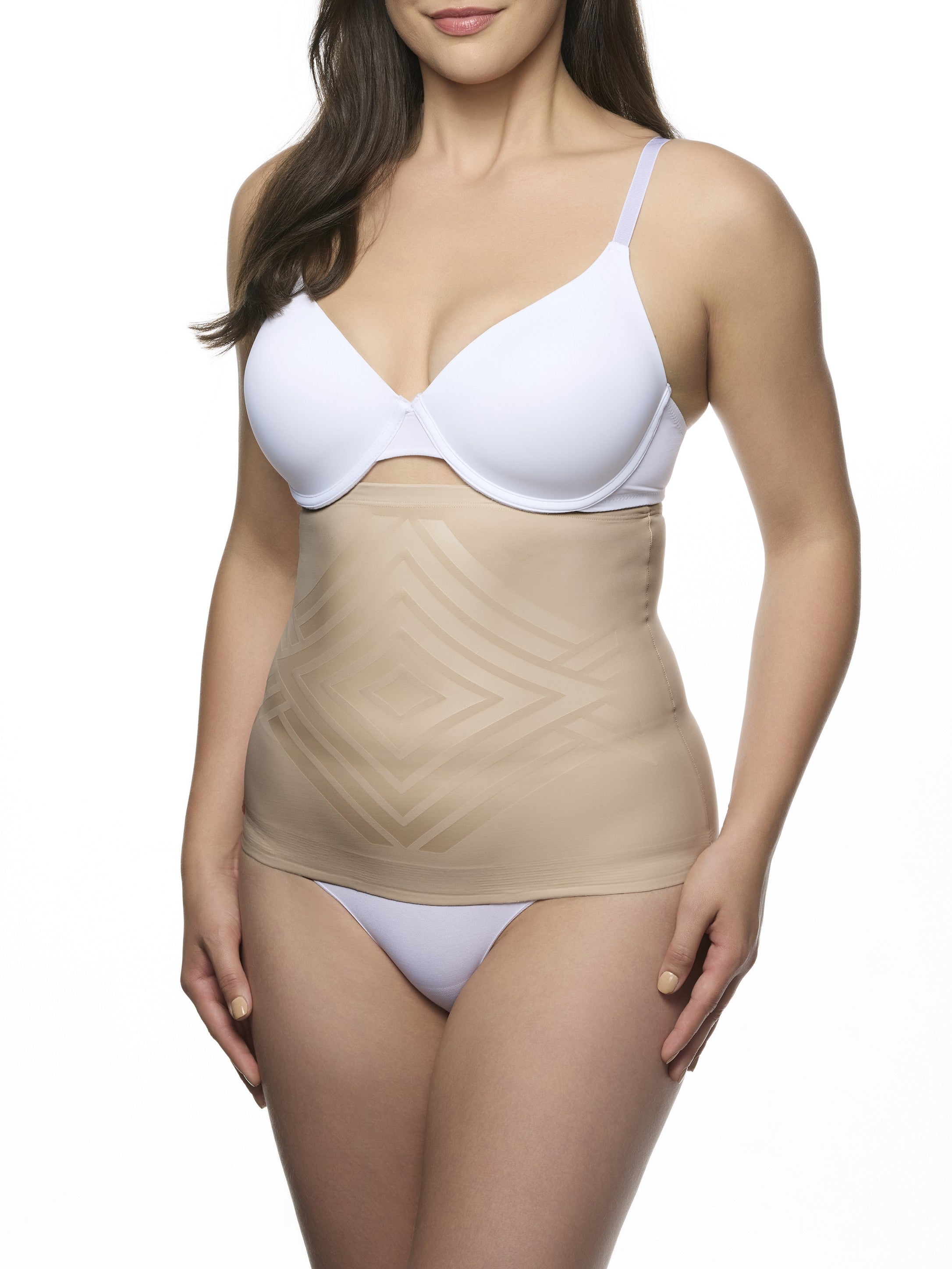 Woman wearing a white bra and beige waist cincher on a white background