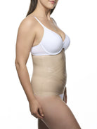 Woman wearing a white bra and beige waist cincher on a white background