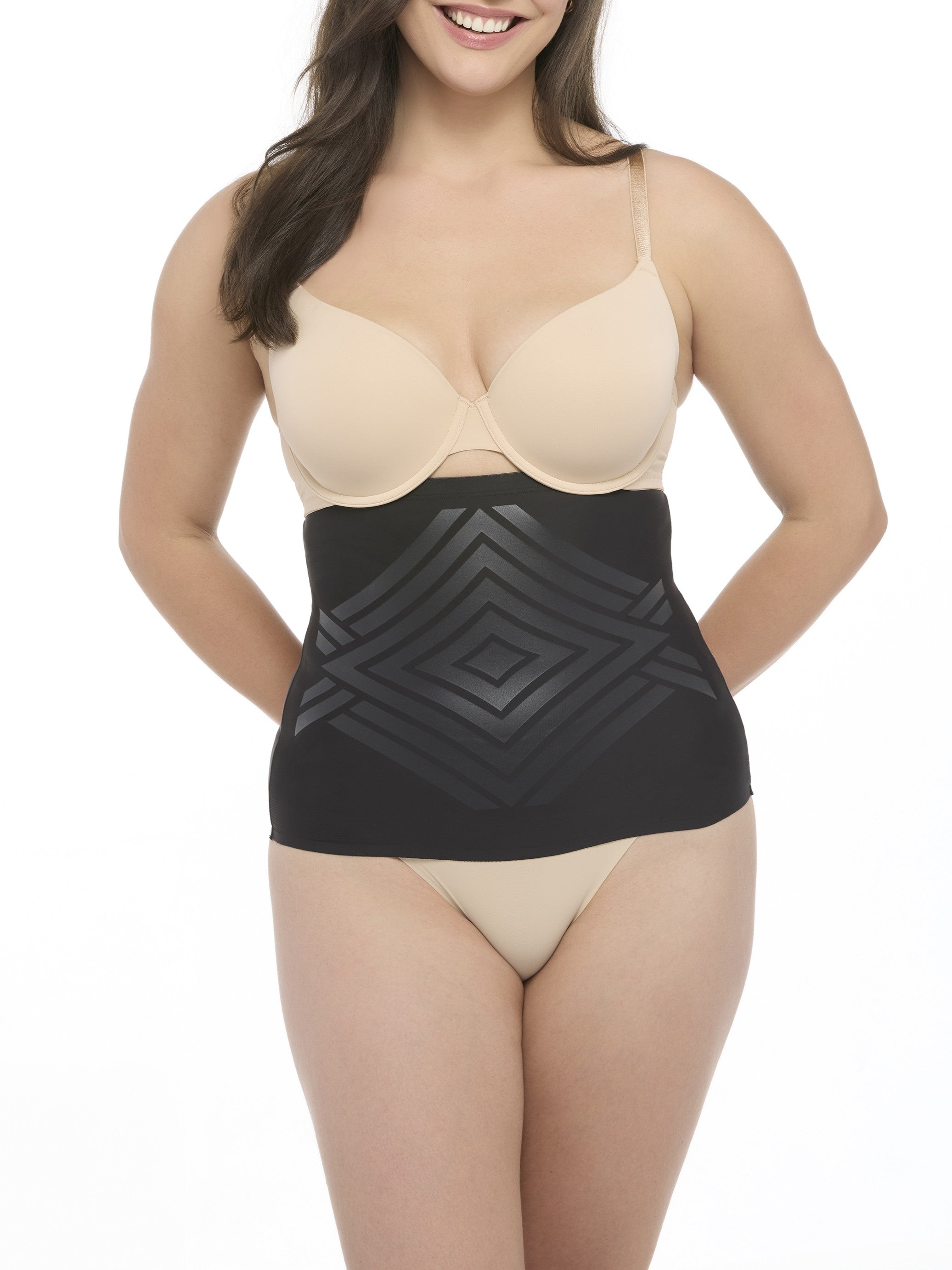 Woman wearing a beige bra and black waist cincher on a white background