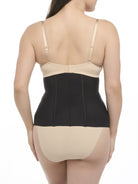 Woman wearing a beige bra and black waist cincher on a white background