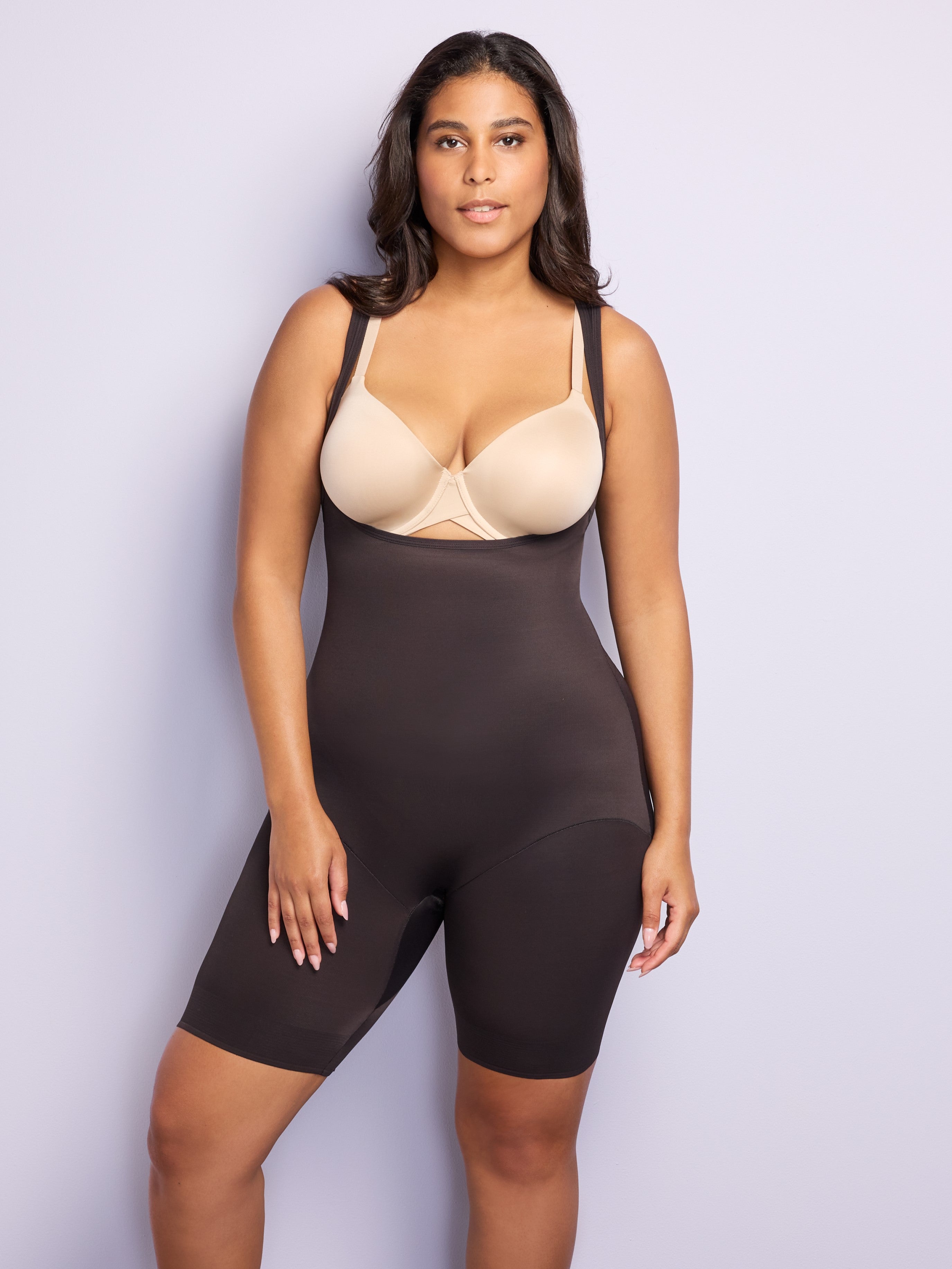 a woman wearing a black open-bust shaping bodysuit romper