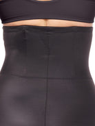 a close-up detail of a woman wearing black high waisted tummy control underwear shapewear