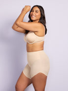 a woman wearing nude tummy control shapewear shorts against a purple wall all-groups