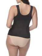 Woman wearing a black shaping camisole and white underwear on a white background
