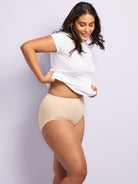 a woman wearing a beige shaping brief and a white t-shirt all-groups