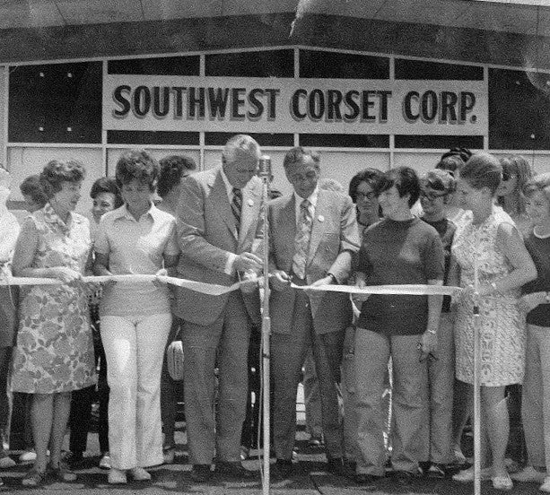 a group of people performing a ribbon cutting ceremony