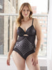 a woman standing in front of a window wearing a black high waisted tummy control panty body shaper all-groups